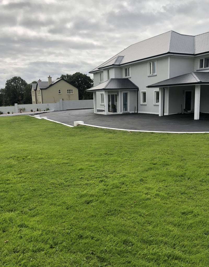 A big house with new tarmac across the front, seen from the lawn