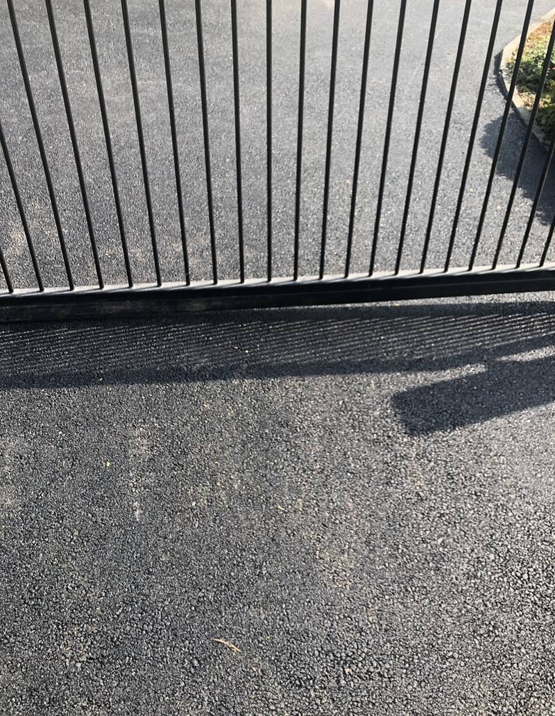 New tarmac laid under a sliding gate