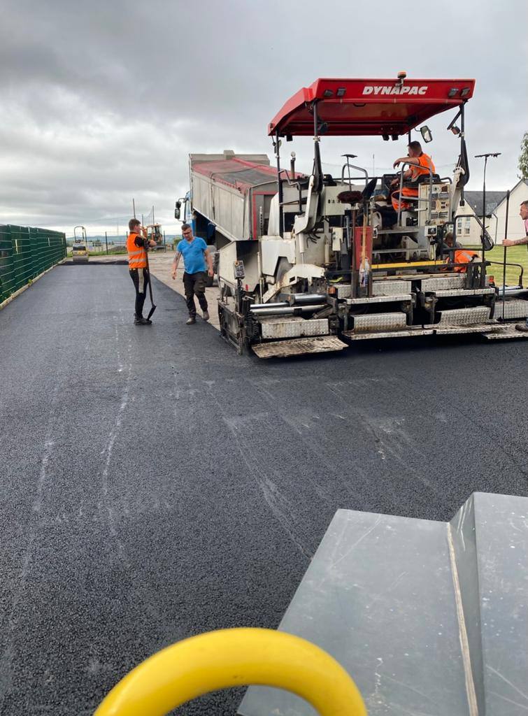 The paver working up a driveway, seen from the roller